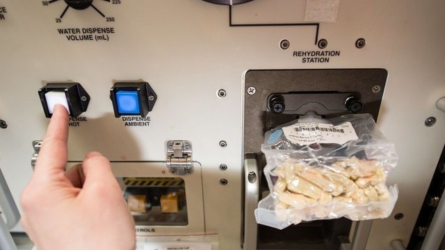 Очень важно при приеме пищи в невесомости избежать появления крошек или любых других остатков — это может помешать работе оборудования. Для того, чтобы обеды, завтраки и ужины проходили максимально удобно и безопасно, существует специальный сервировочный стол. Это агрегат с креплениями, где хранятся банки и тюбики с едой, а также со специальными гнездами для разогрева продуктов. Есть в нем и устройство для борьбы с крошками — встроенный в стол вентилятор, который космонавты прозвали «крохобором». На фото: «космический чизбургер», собранный Терри Вертсом из говядины, сыра, томатной пасты и горчицы на лепешке-тортилье