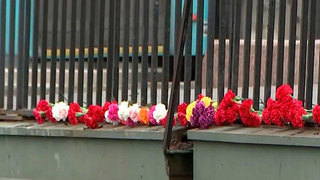 Жители Петербурга несут цветы к месту падения автобуса