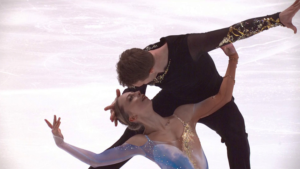 спортивная пара фигуристов обнимается после проката